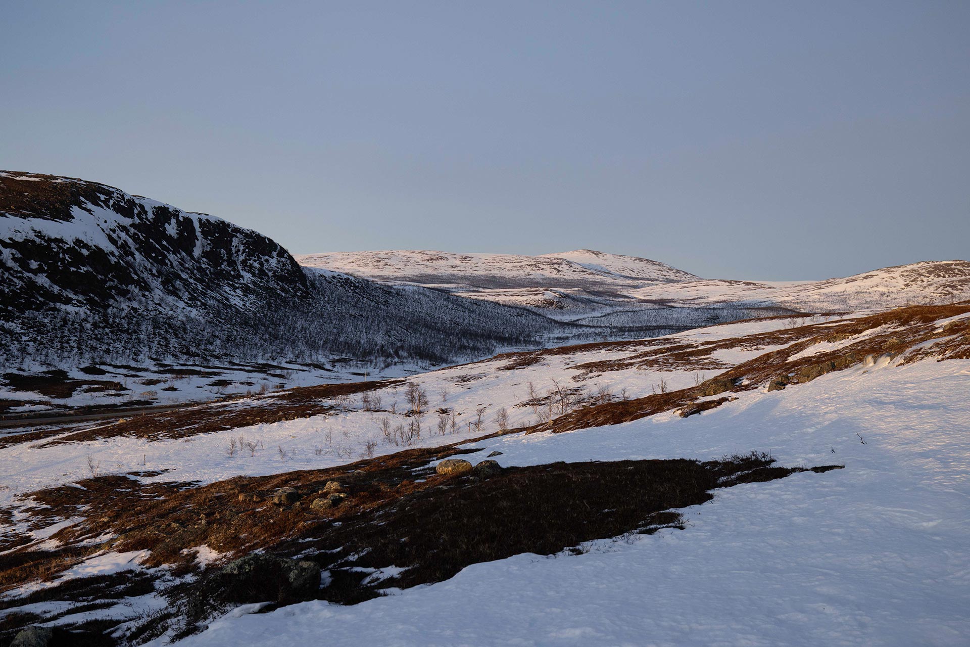 View of the Arctic tundra landscape patchy snow clear sky